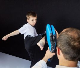 The coach teaches the athlete to hit the simulator